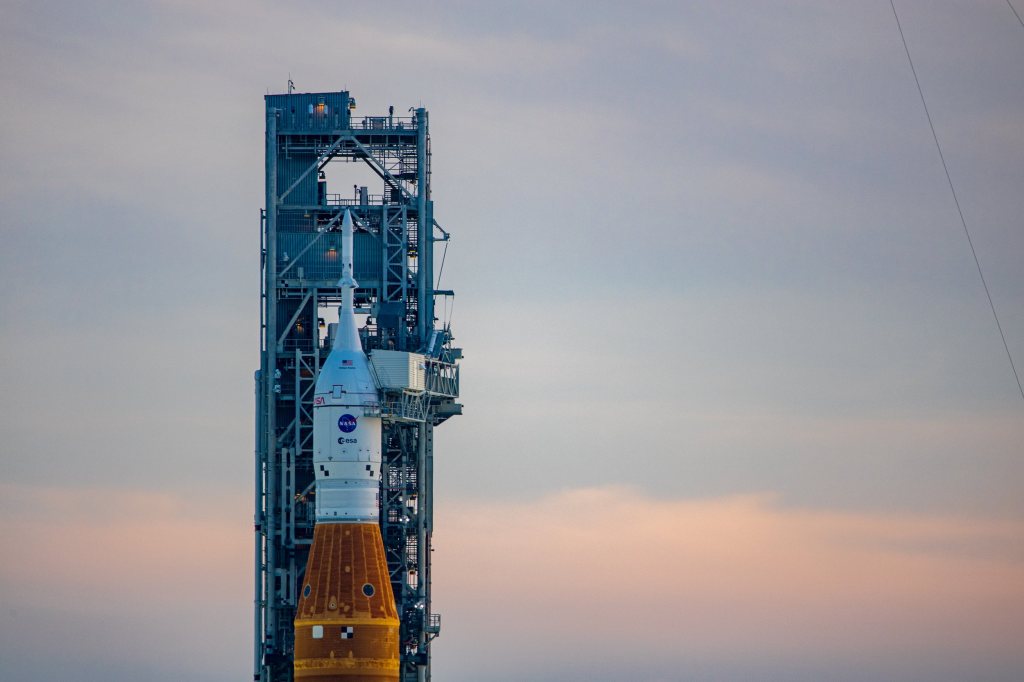 Spectators watch a sunrise from the Max Brewer Bridge while waiting to view  the launch on Pad 39B for the Artemis I mission to orbit the moon at the  Kennedy Space Center