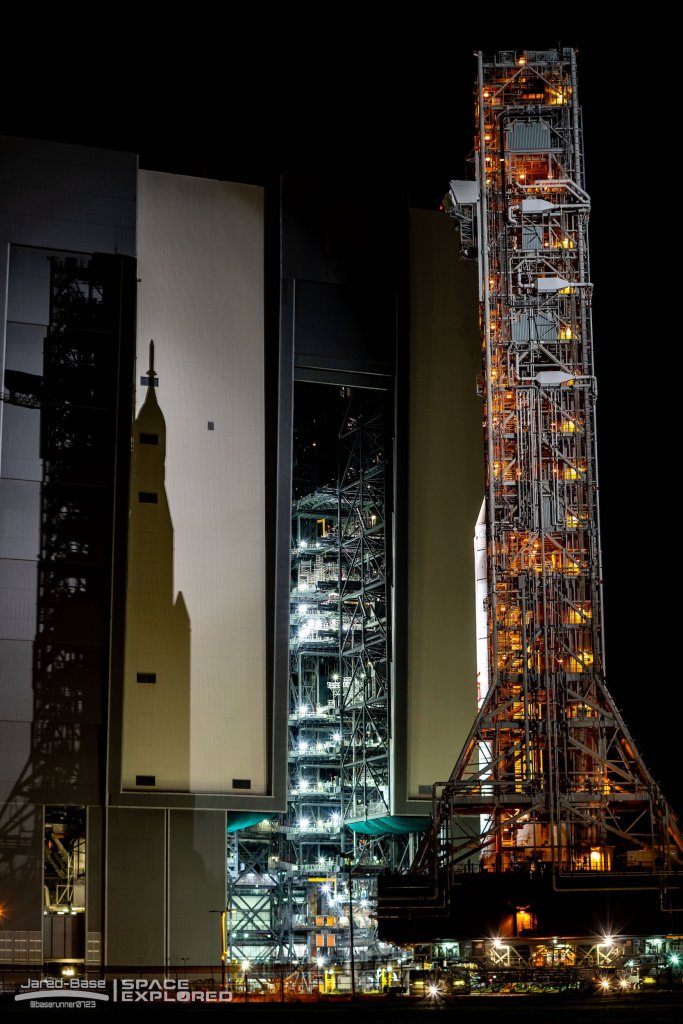 SLS casts a shadow on the VAB during the rollout for launch of Artemis 1.