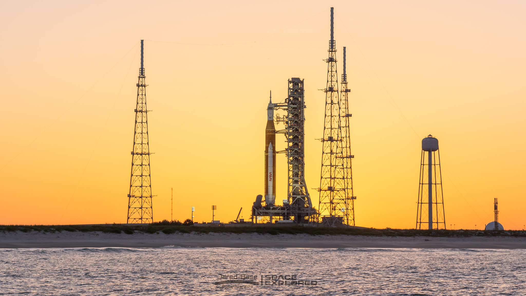 Spectators watch a sunrise from the Max Brewer Bridge while waiting to view  the launch on Pad 39B for the Artemis I mission to orbit the moon at the  Kennedy Space Center
